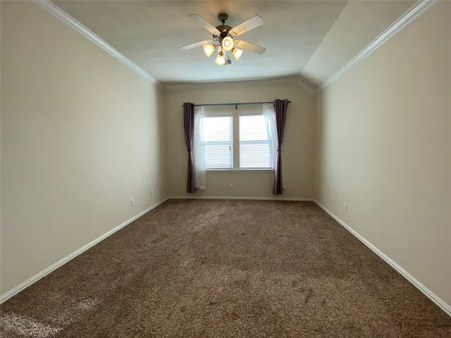 an empty room with a window and a ceiling fan