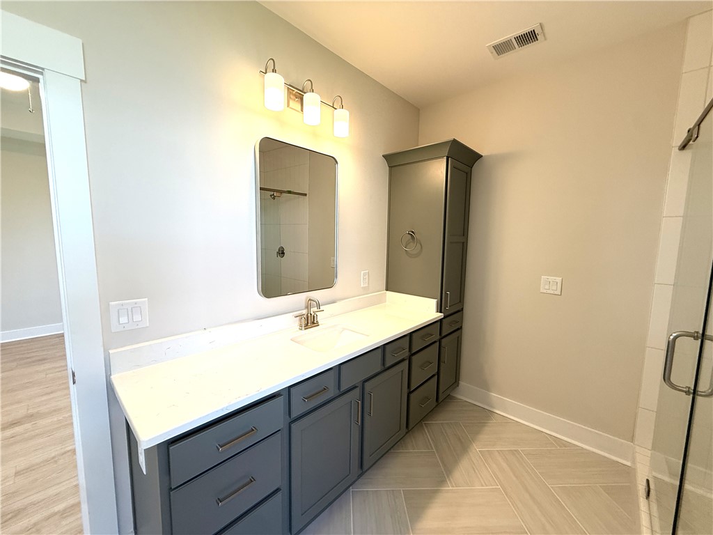 504 Tilman Court Anderson, SC 29621 - Photo 20 of 28 This primary bathroom features a double vanity and a glass-enclosed shower, offering a serene retreat.