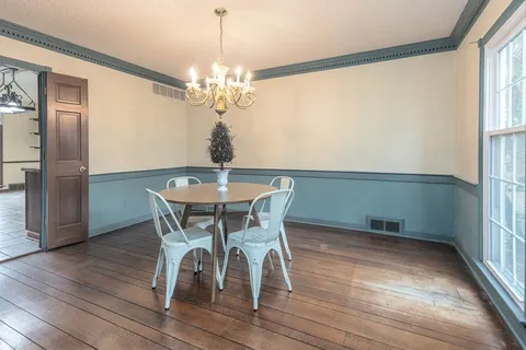 a view of a dining room with furniture a chandelier and wooden floor