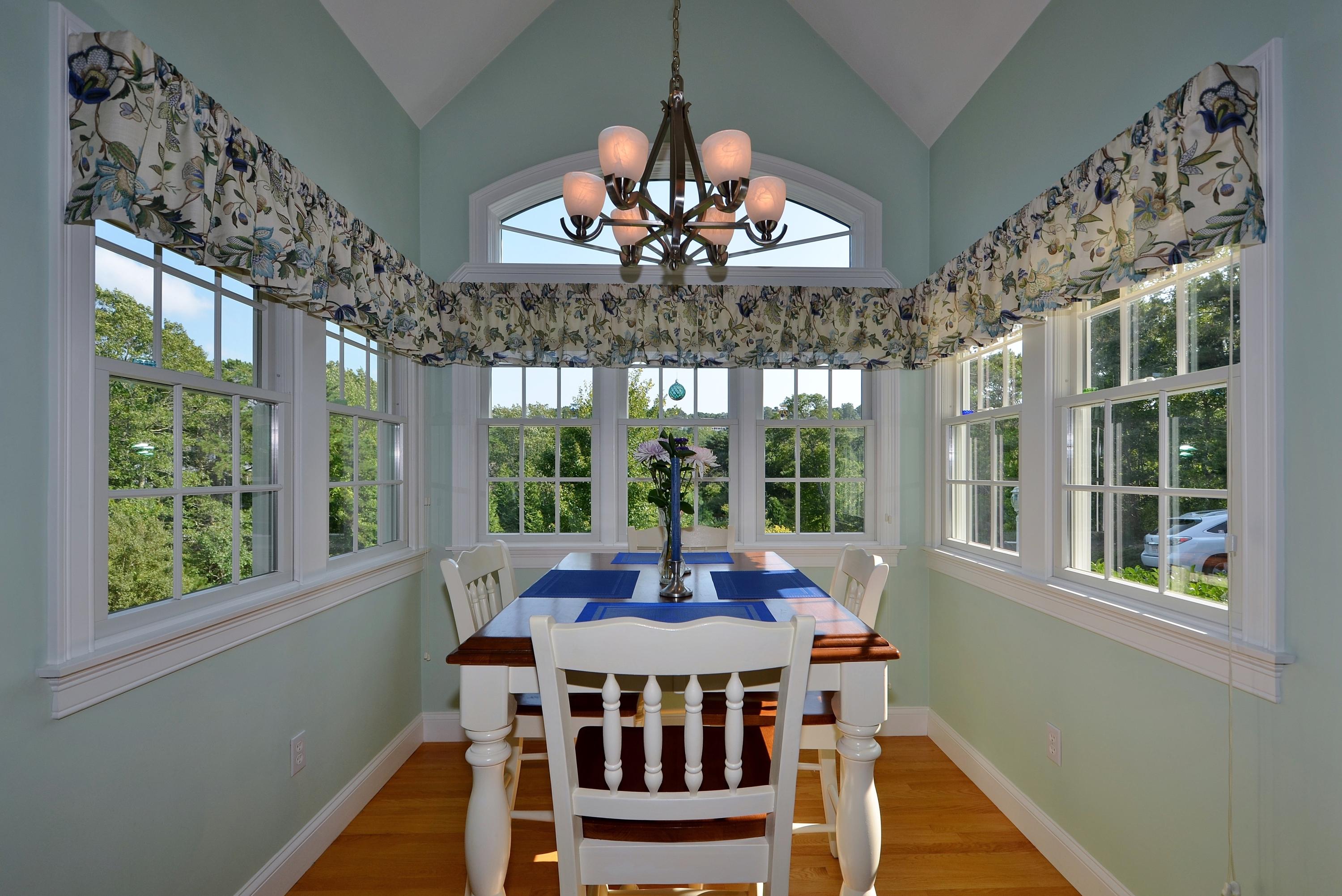 121 Cairn Ridge Road East Falmouth, MA 02536 - Photo 11 of 28 a view of a dining room with furniture a chandelier and large windows
