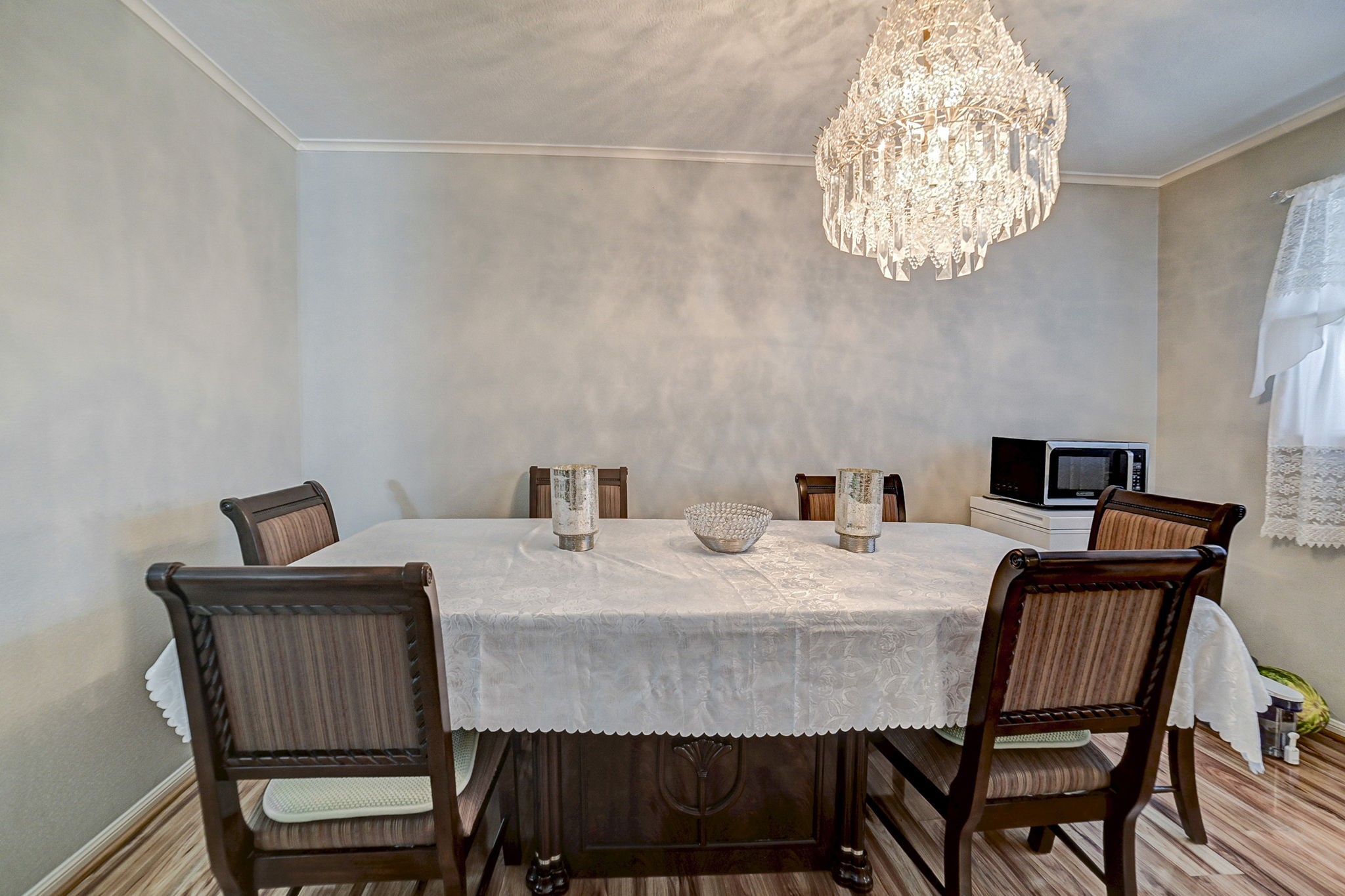 7900 Westheimer Road, Unit 202 Houston, TX 77063 - Photo 8 of 25 Elegant dining room featuring a sophisticated chandelier, classic table setting with a lace tablecloth, and cozy wooden chairs, perfect for intimate gatherings.