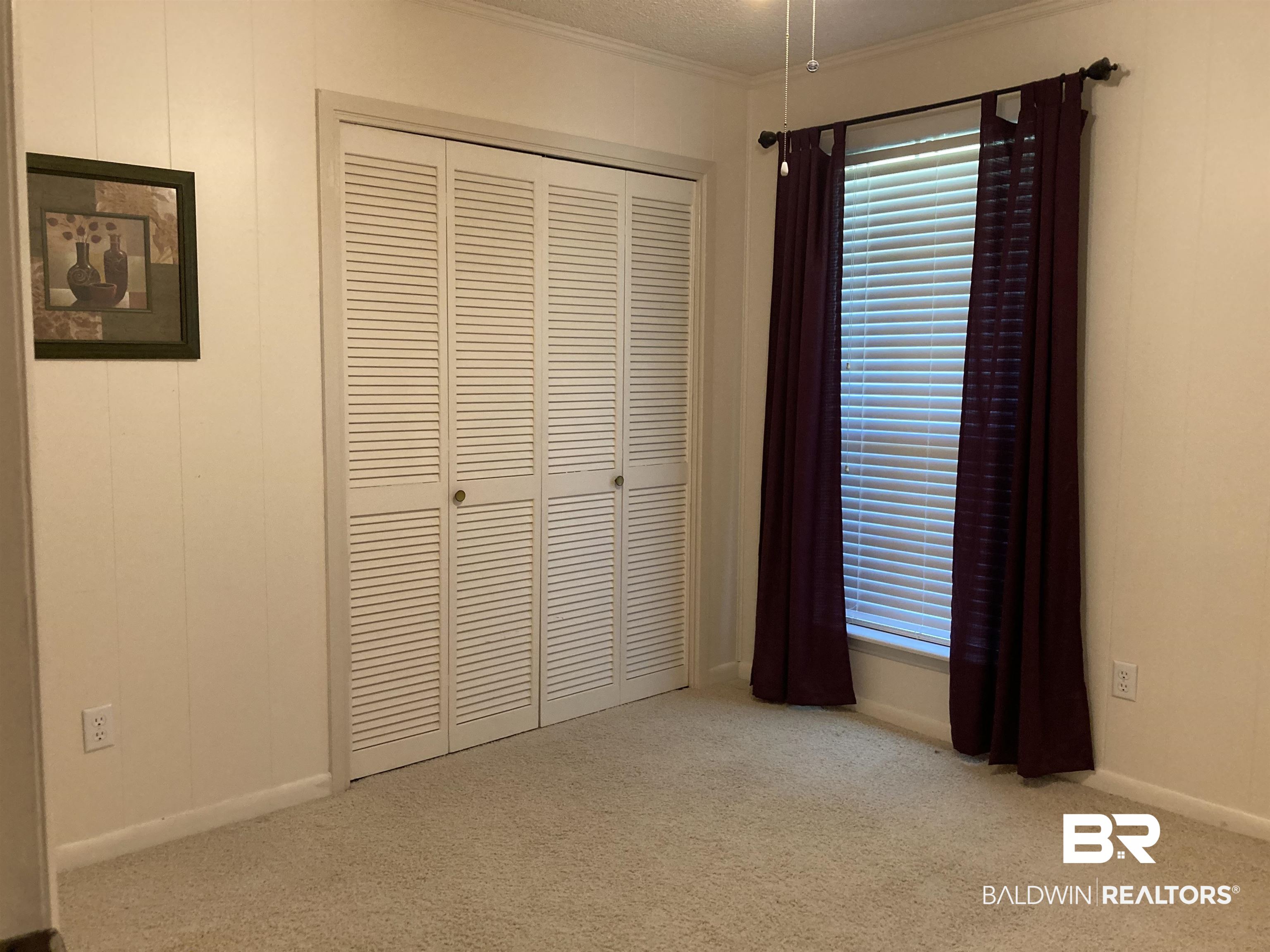 6151 Meadows Road Walnut Hill, FL 32568 - Photo 16 of 29 Unfurnished bedroom with light carpet, a closet, a textured ceiling, and ornamental molding