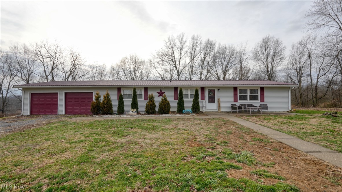 10614 Linwood Road Pleasant City, OH 43772 - Photo 1 of 48 Ranch-style home featuring driveway, a front lawn, an attached garage, and a metal roof