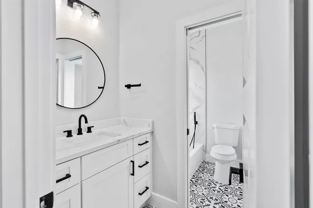 a white toilet sitting next to a white wall