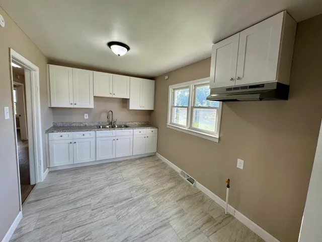 a kitchen with granite countertop white cabinets and white appliances
