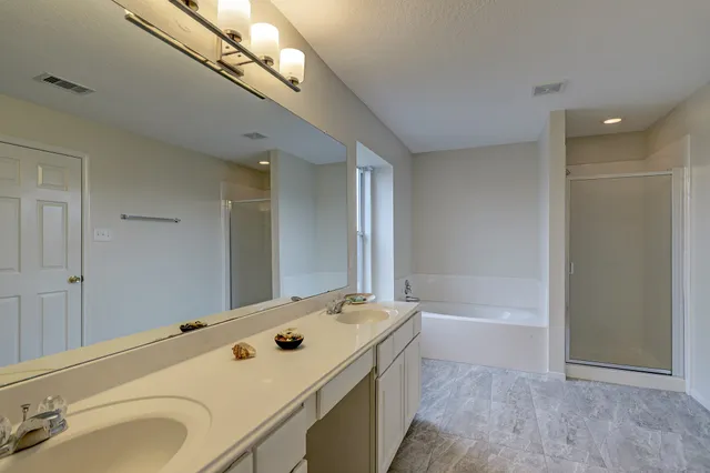 a bathroom with a tub a sink and a mirror