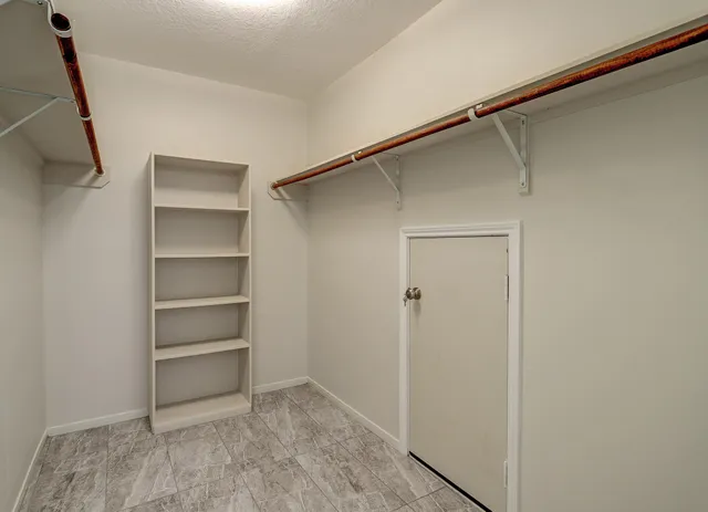 a view of walk in closet with empty racks