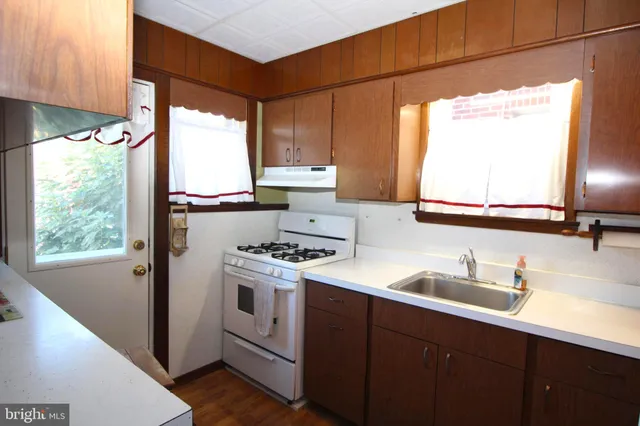 a kitchen with a sink window and cabinets
