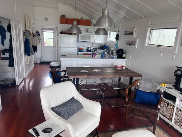 a kitchen with stainless steel appliances table chairs and wooden floor