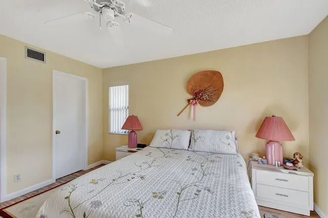 a bedroom with a large bed and a chandelier fan