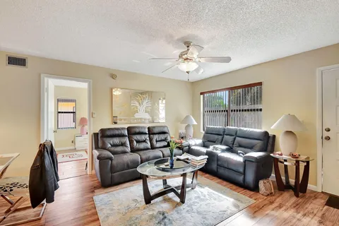 a living room with furniture a ceiling fan and a window