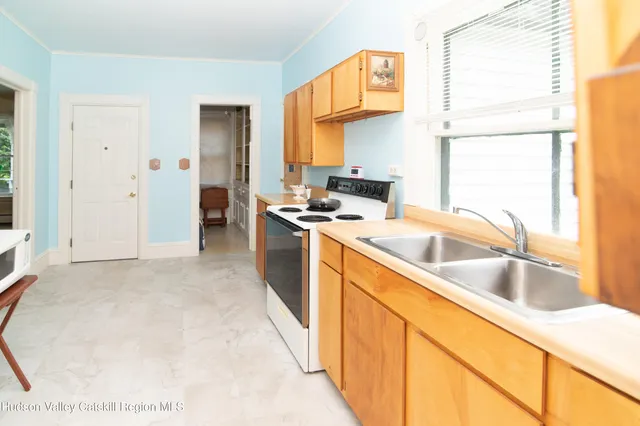 a kitchen that has a sink a stove and a refrigerator