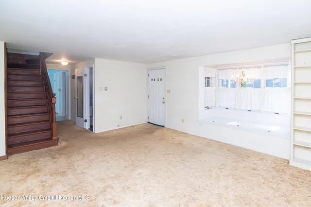 a view of an empty room with stairs and ventilation