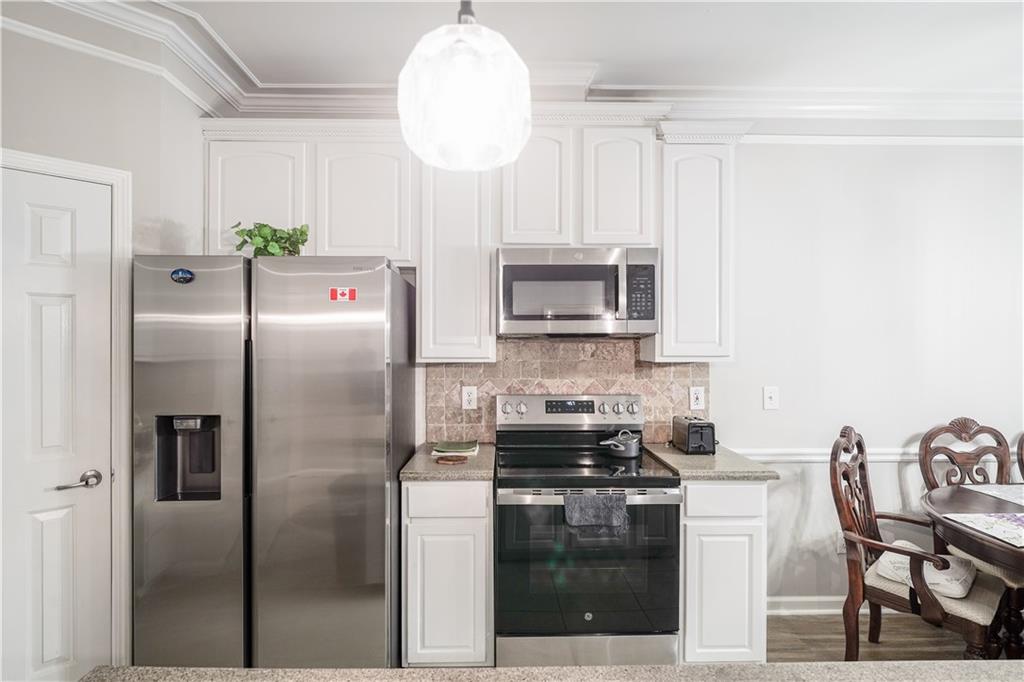 5331 Sherwin Drive Norcross, GA 30093 - Photo 9 of 29 a kitchen with stainless steel appliances granite countertop a refrigerator a stove a sink and a dining table with wooden floor