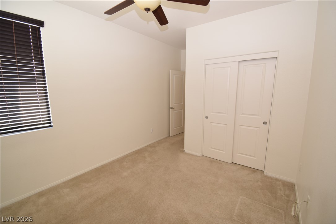 3622 Via Terracina Henderson, NV 89052 - Photo 10 of 22 A well-lit bedroom features plush carpeting and a convenient closet with sliding doors.