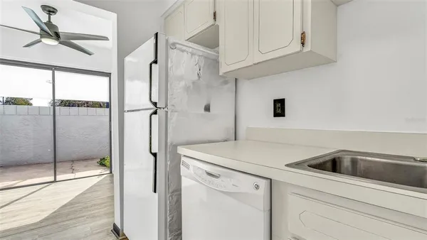 a kitchen with a refrigerator sink and cabinets
