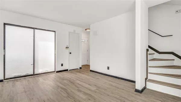 an empty room with wooden floor and white walls