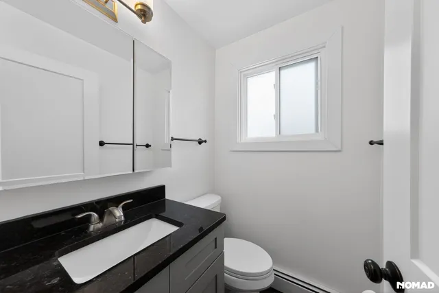 a bathroom with a toilet a sink and a window