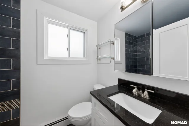 a bathroom with a granite countertop sink toilet a mirror and a shower