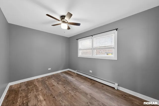 a view of a big room with wooden floor and windows
