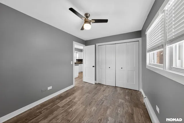 a view of a livingroom with a ceiling fan & wooden floor