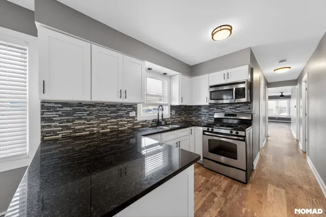 a kitchen with stainless steel appliances granite countertop a stove a sink and a microwave