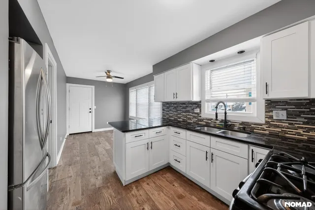 a kitchen with granite countertop a sink stainless steel appliances and cabinets