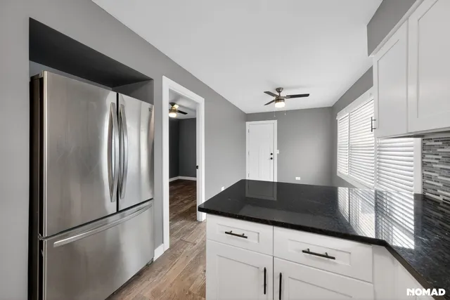 a kitchen with granite countertop a refrigerator and a sink