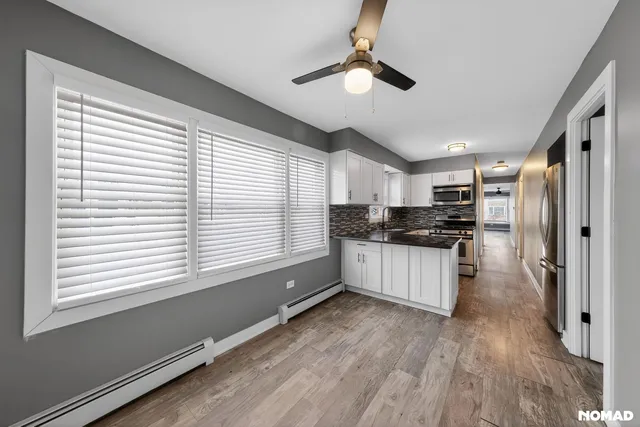 a kitchen with stainless steel appliances kitchen island granite countertop a refrigerator and a stove top oven