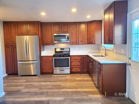 128 South Lilac Street Ridgecrest, CA 93555 - Photo 5 of 24 a kitchen with stainless steel appliances granite countertop a refrigerator a stove a sink and a microwave