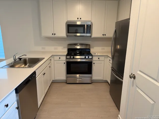 a kitchen with stainless steel appliances granite countertop a stove a microwave and a refrigerator