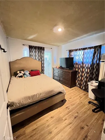 a large bed sitting in a bedroom and a flat tv screen on dresser