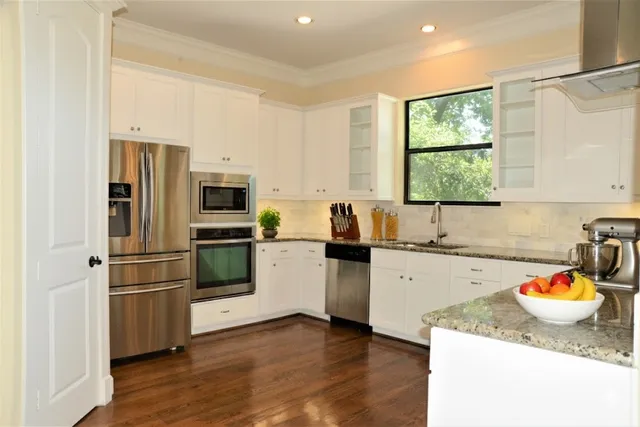 a kitchen with granite countertop stainless steel appliances a sink and a window