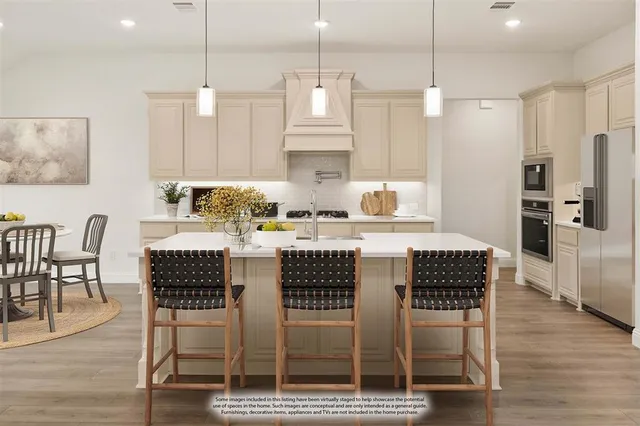 a kitchen with stainless steel appliances granite countertop a kitchen island a table and chairs