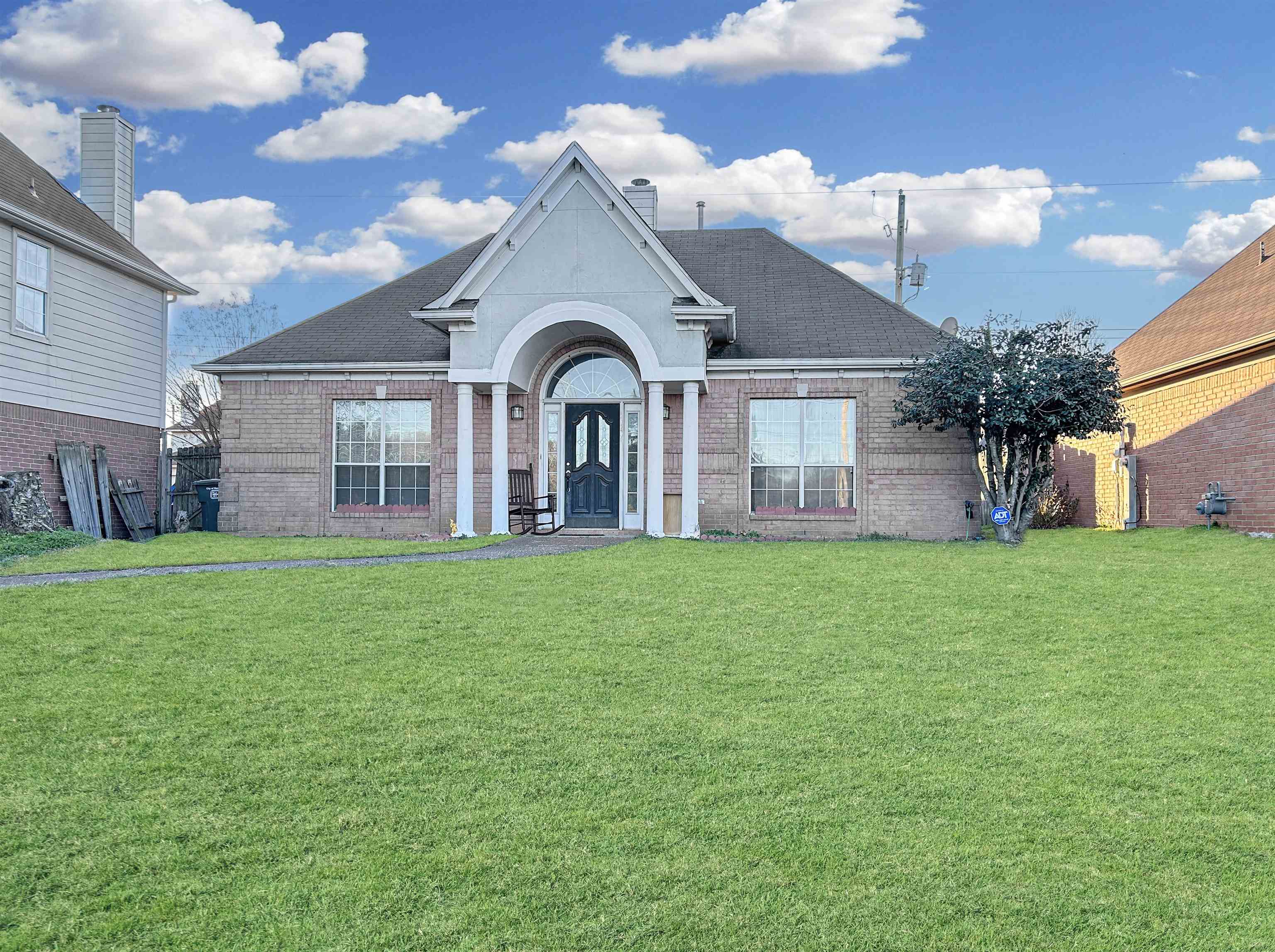 Ranch-style home with a front lawn, brick siding, and roof with shingles