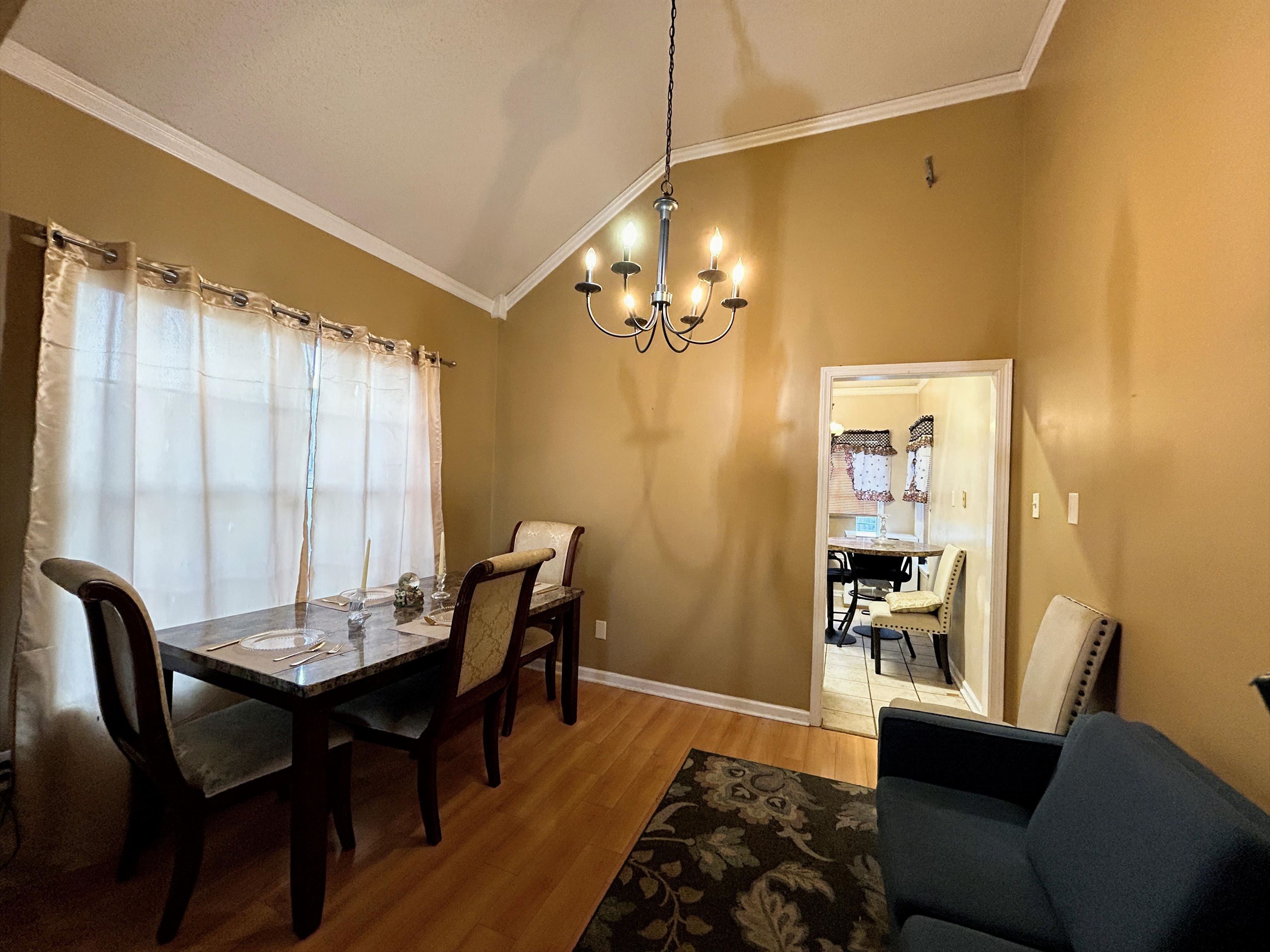 741 North Sanga Road Memphis, TN 38018 - Photo 11 of 13 Dining area with suspended lighting, crown molding, light wood-style floors, and vaulted ceiling