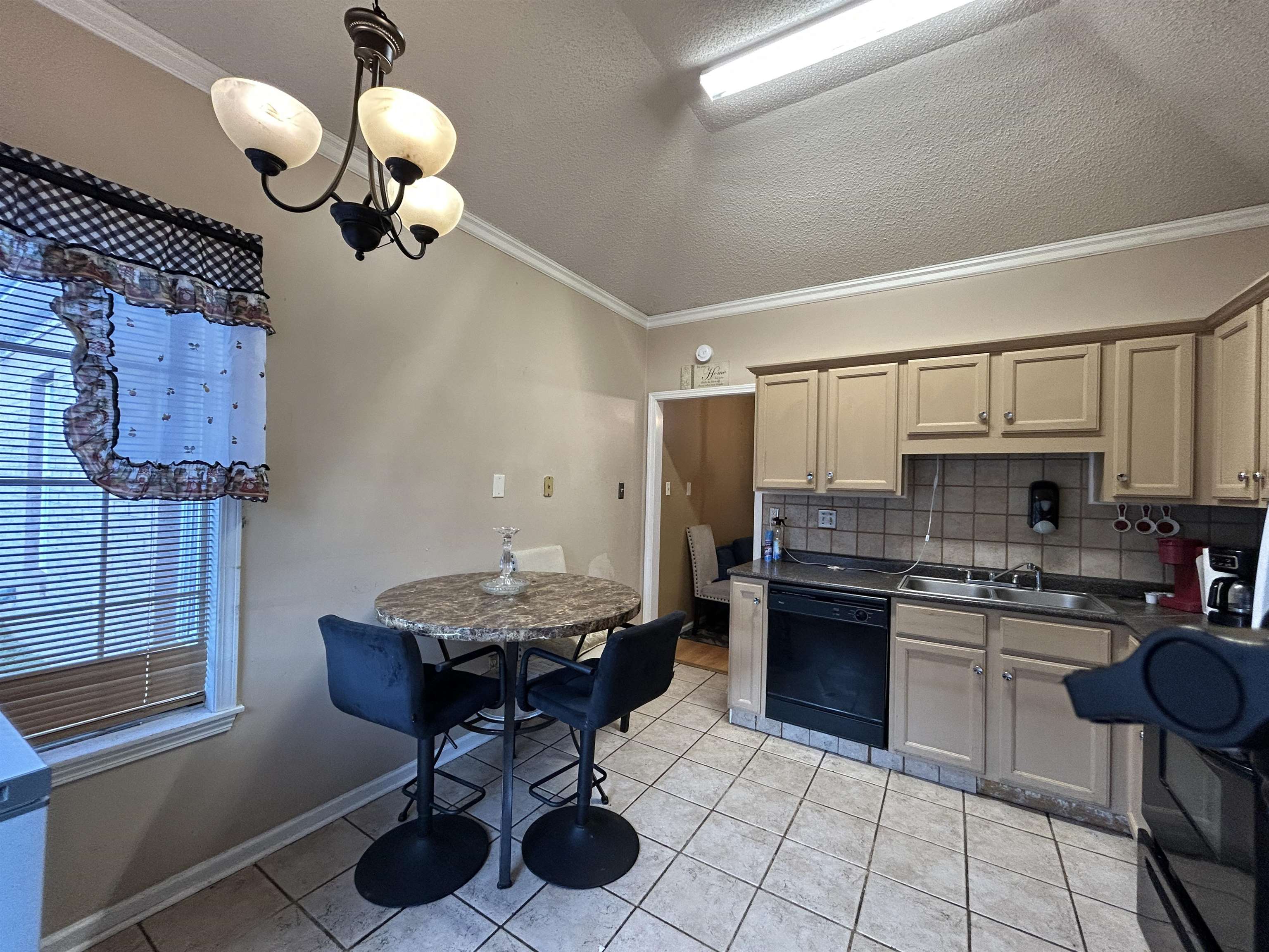 741 North Sanga Road Memphis, TN 38018 - Photo 2 of 13 Kitchen with crown molding, decorative backsplash, dark countertops, dishwasher, and a textured ceiling
