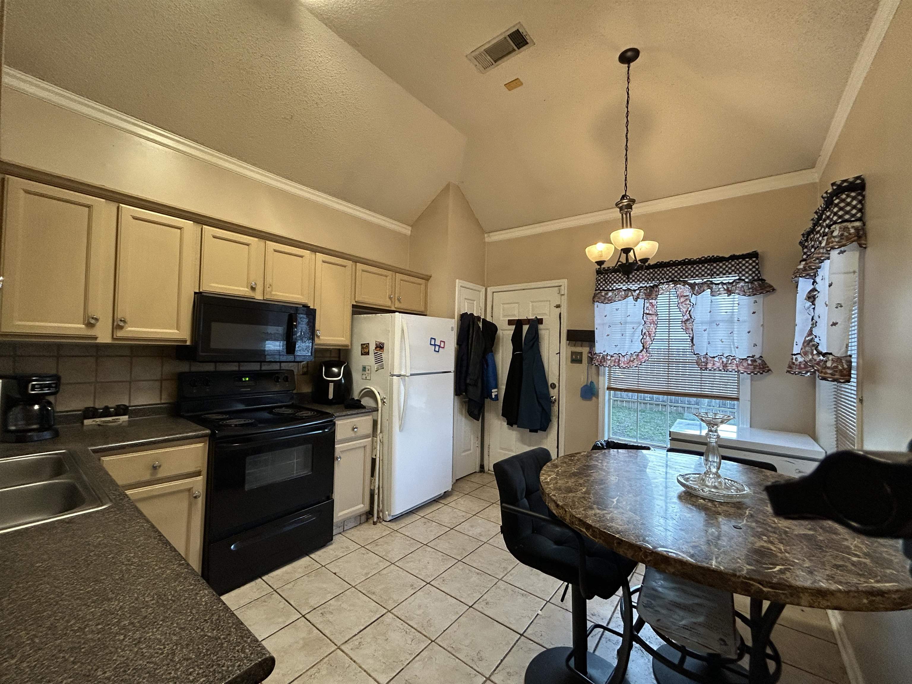 741 North Sanga Road Memphis, TN 38018 - Photo 3 of 13 Kitchen featuring crown molding, black appliances, dark countertops, suspended lighting, and vaulted ceiling