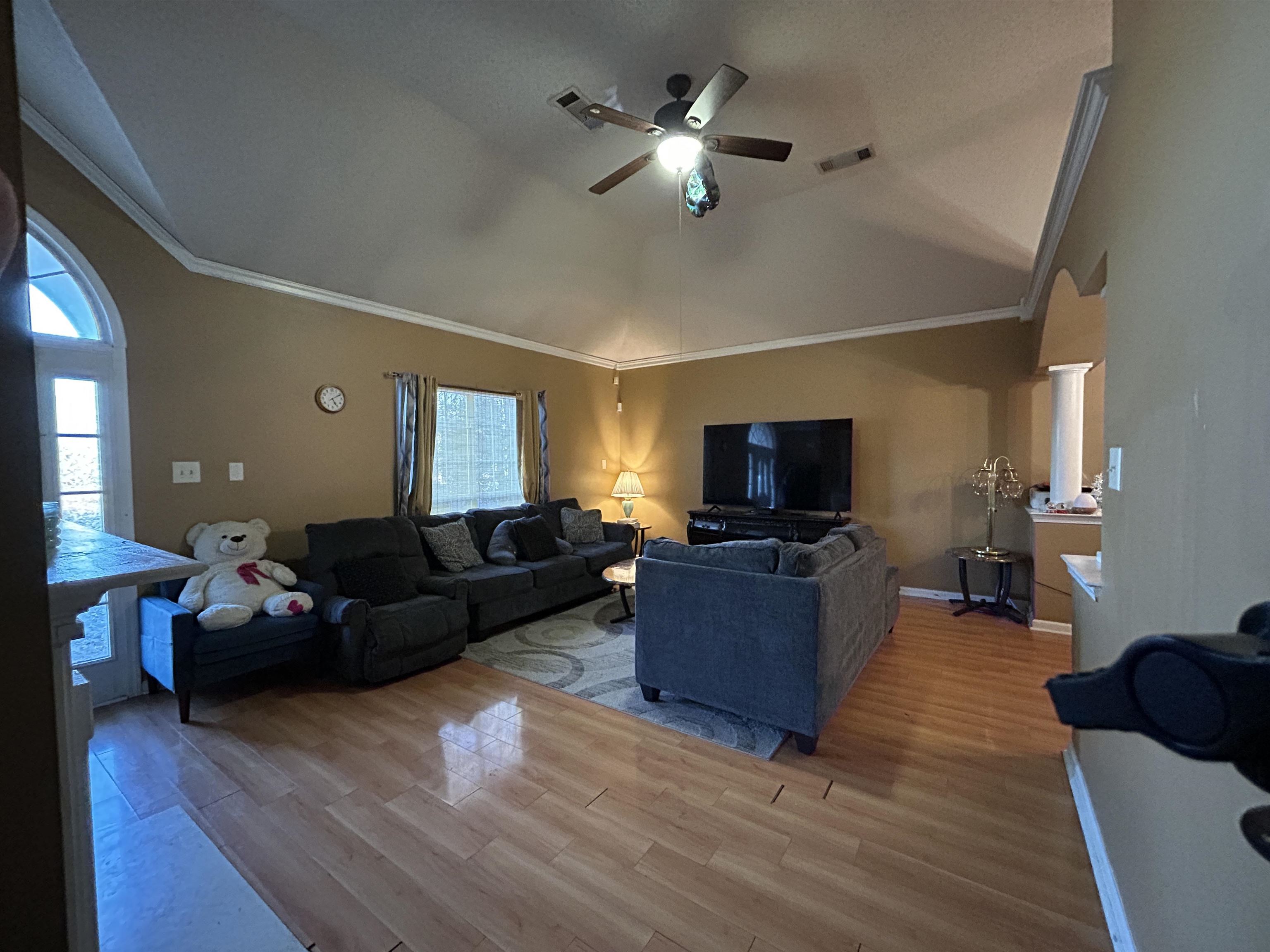 741 North Sanga Road Memphis, TN 38018 - Photo 5 of 13 Living room with ceiling fan, wood finished floors, ornamental molding, lofted ceiling, and arched walkways