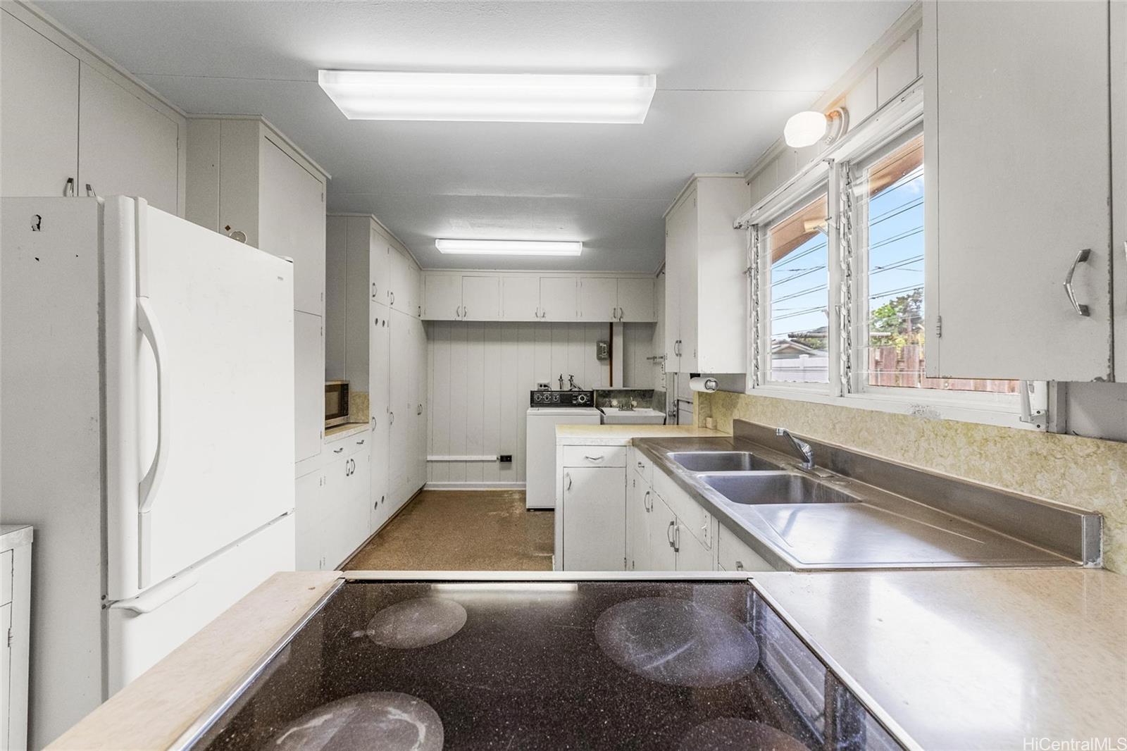 5558 Pia Street Honolulu, HI 96821 - Photo 10 of 25 a kitchen with a refrigerator a sink and a stove top oven