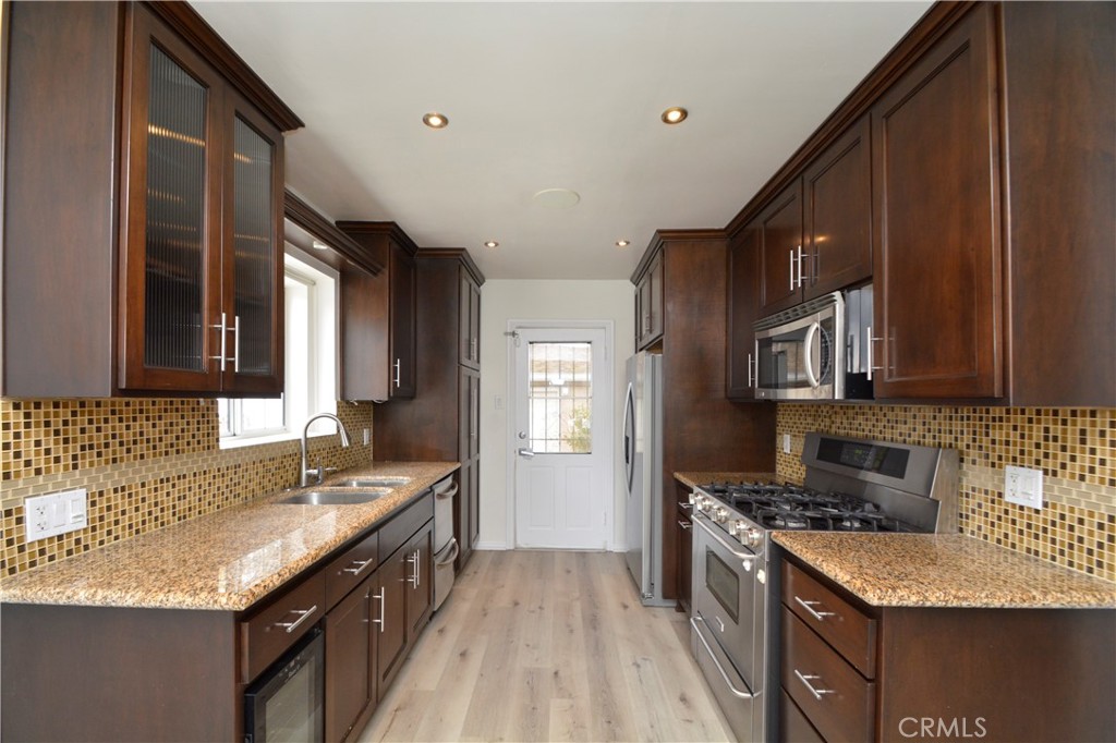 12301 Rives Avenue Downey, CA 90242 - Photo 3 of 20 a kitchen with granite countertop a sink stove and refrigerator