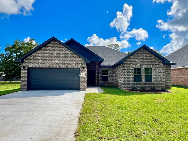 a front view of a house with yard and garage