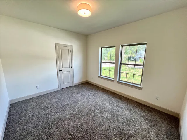 an empty room with windows and closet