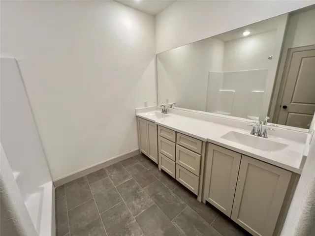 a spacious bathroom with a double vanity sink and mirror
