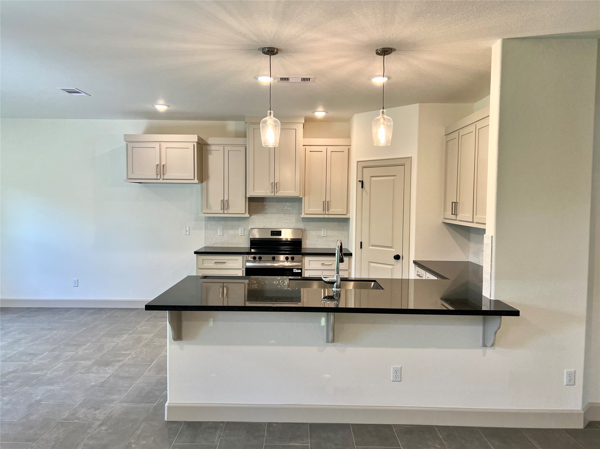 1003 South Anderson Street Angleton, TX 77515 - Photo 3 of 20 a kitchen with kitchen island a stove a sink and a refrigerator