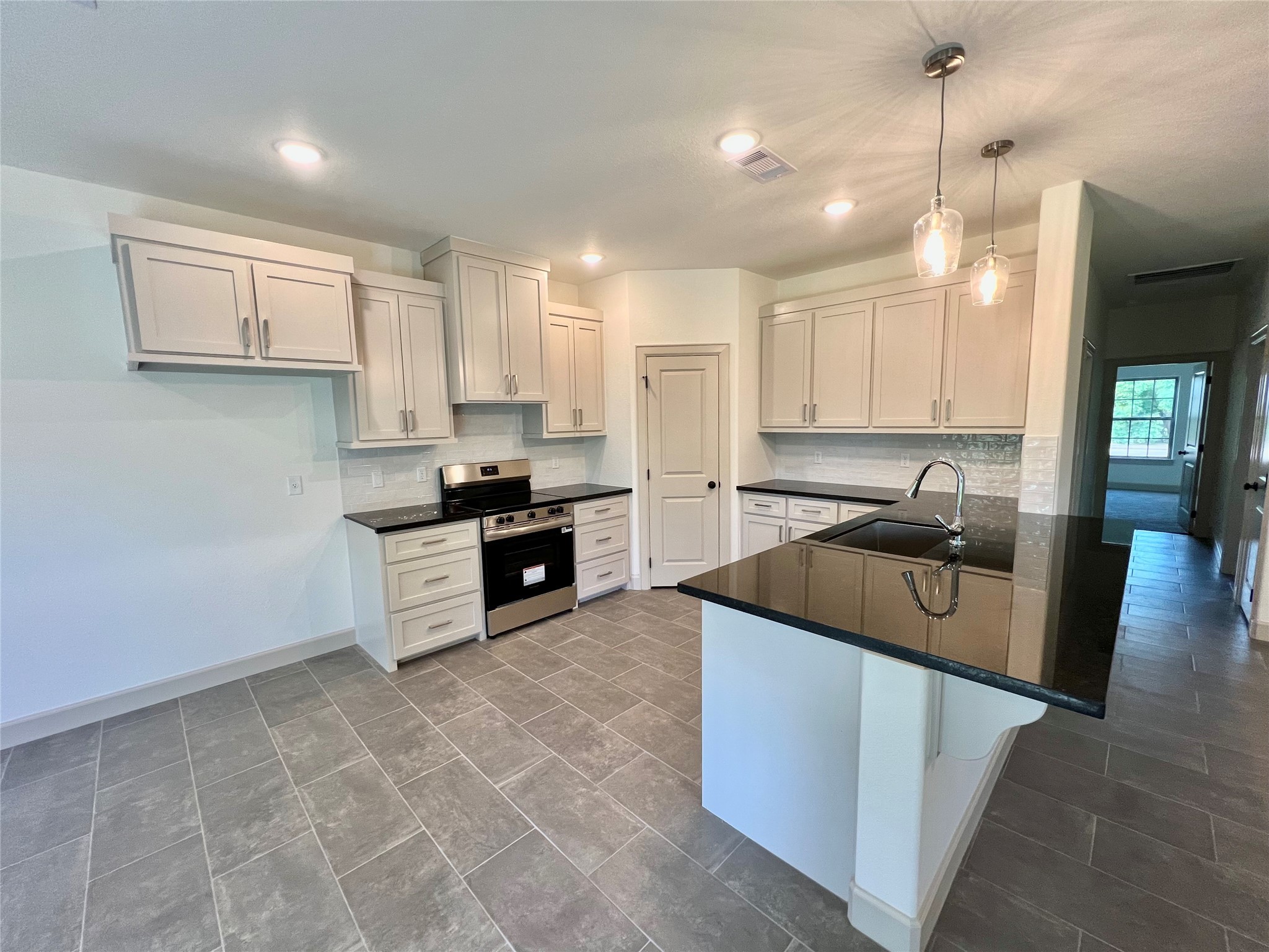 1003 South Anderson Street Angleton, TX 77515 - Photo 4 of 20 a kitchen with stainless steel appliances granite countertop a sink a stove and a refrigerator