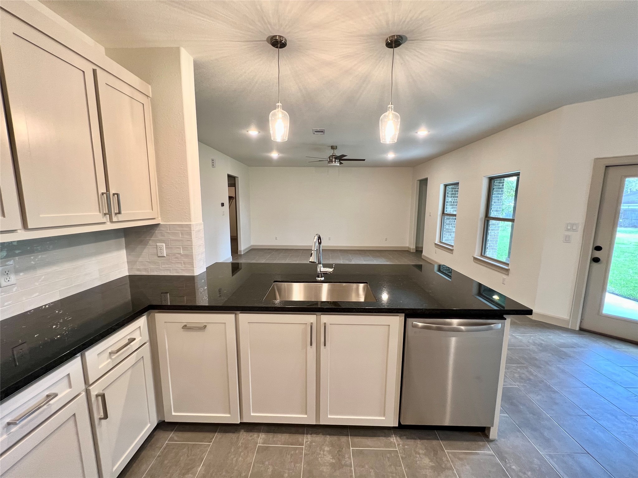 1003 South Anderson Street Angleton, TX 77515 - Photo 5 of 20 a kitchen with granite countertop a sink and dishwasher a stove top oven with wooden floor