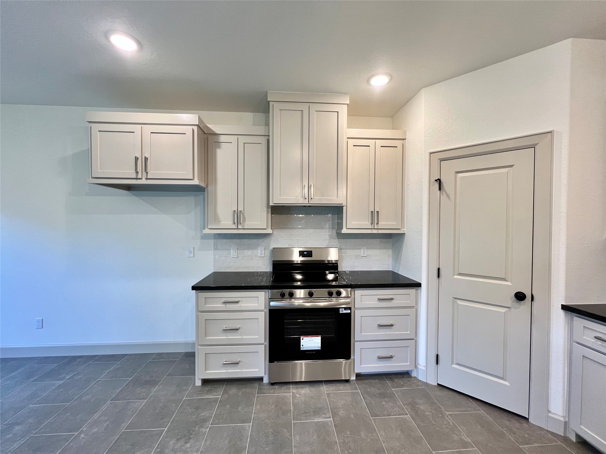 1003 South Anderson Street Angleton, TX 77515 - Photo 7 of 20 a kitchen with stainless steel appliances granite countertop white cabinets and stove