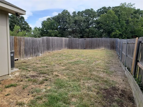 a view of garden with wooden fence
