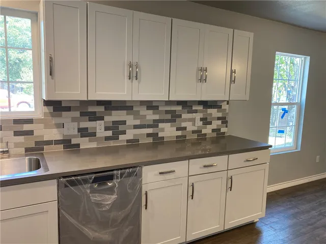a kitchen with stainless steel appliances granite countertop a sink a stove and cabinets